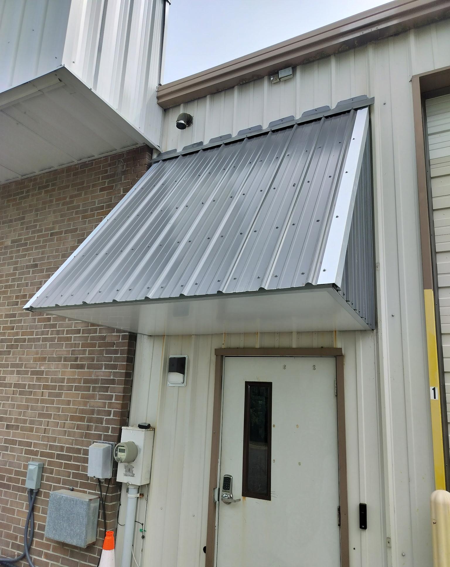 Standing seam metal awning above a commercial entrance