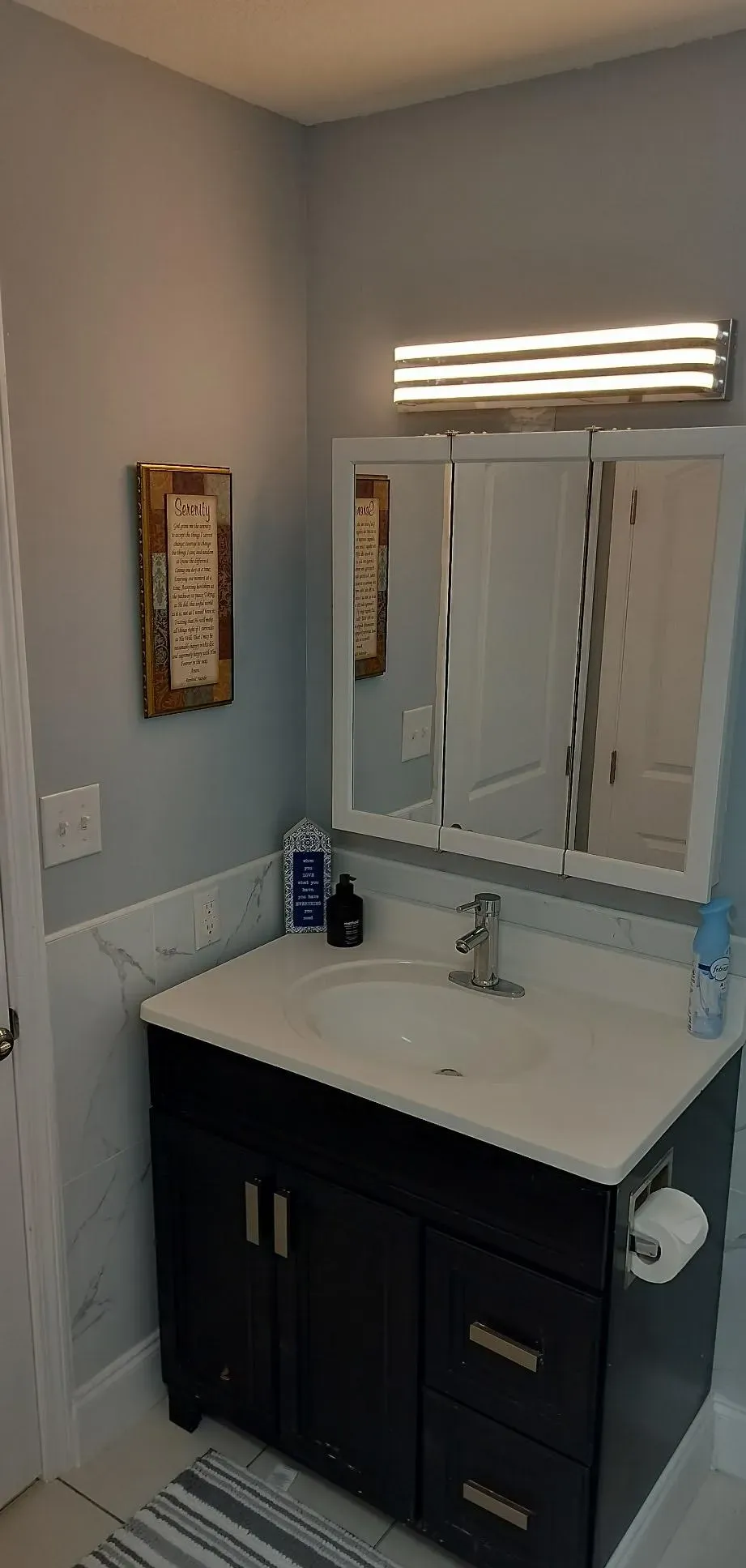 Remodeled bathroom vanity with new countertop and mirror